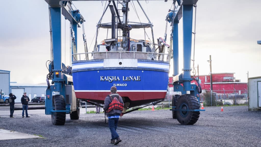 Man transporting fishing boat in ilwaco with a lift